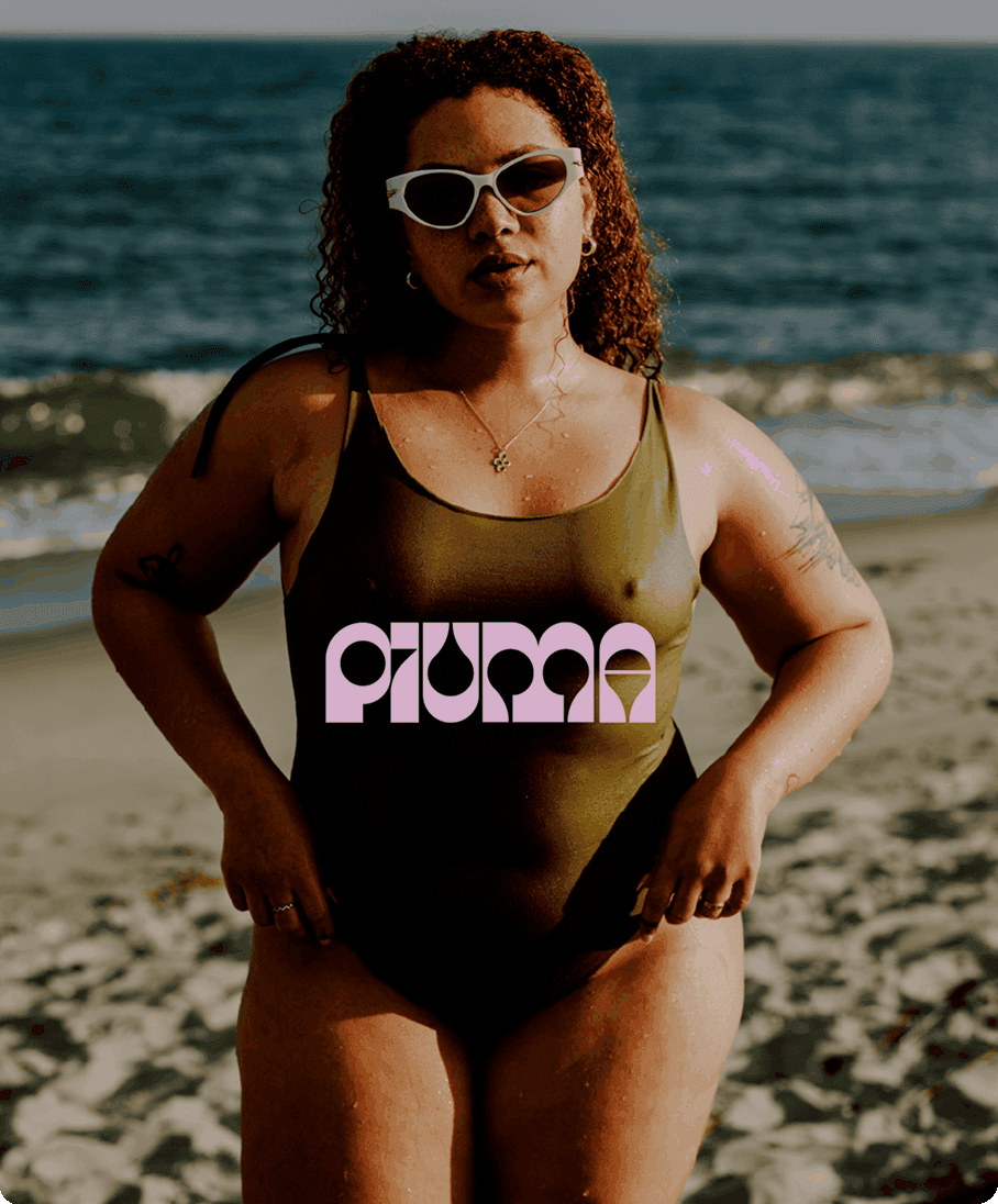 Piuma swimwear campaign portrait on a beach with the Piuma logo